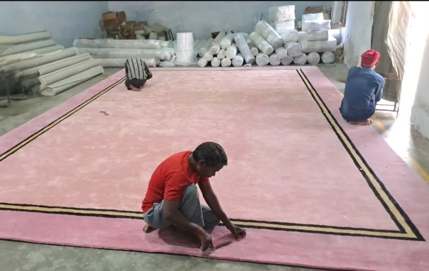 Artisans Finishing Oversized Hospitality Rug on Factory Floor